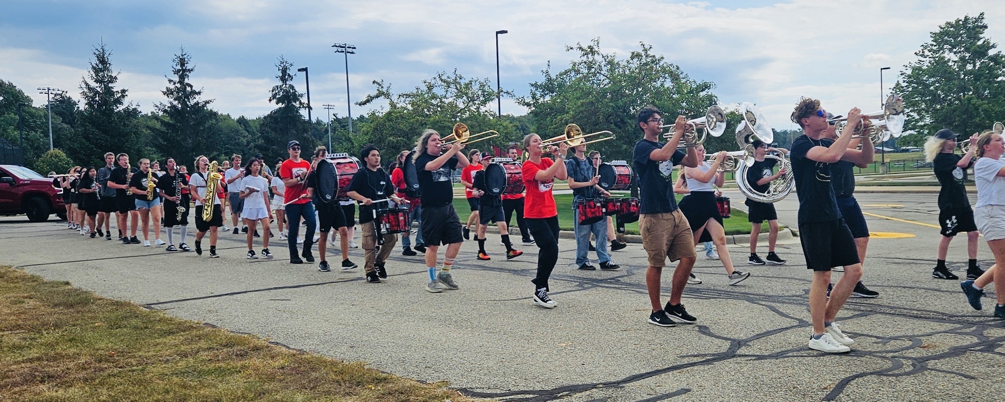 Students marching in the homecoming parade playing instruments